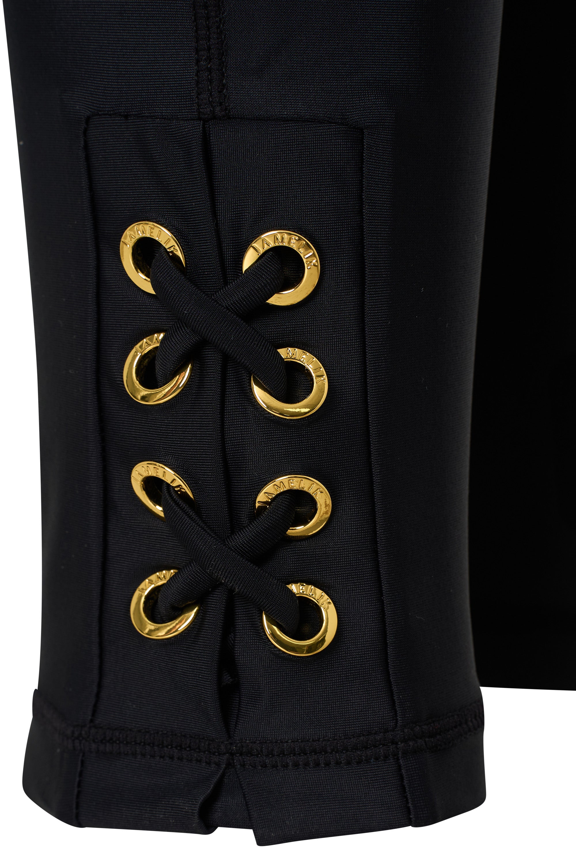 Black pants with gold eyelets on a white background