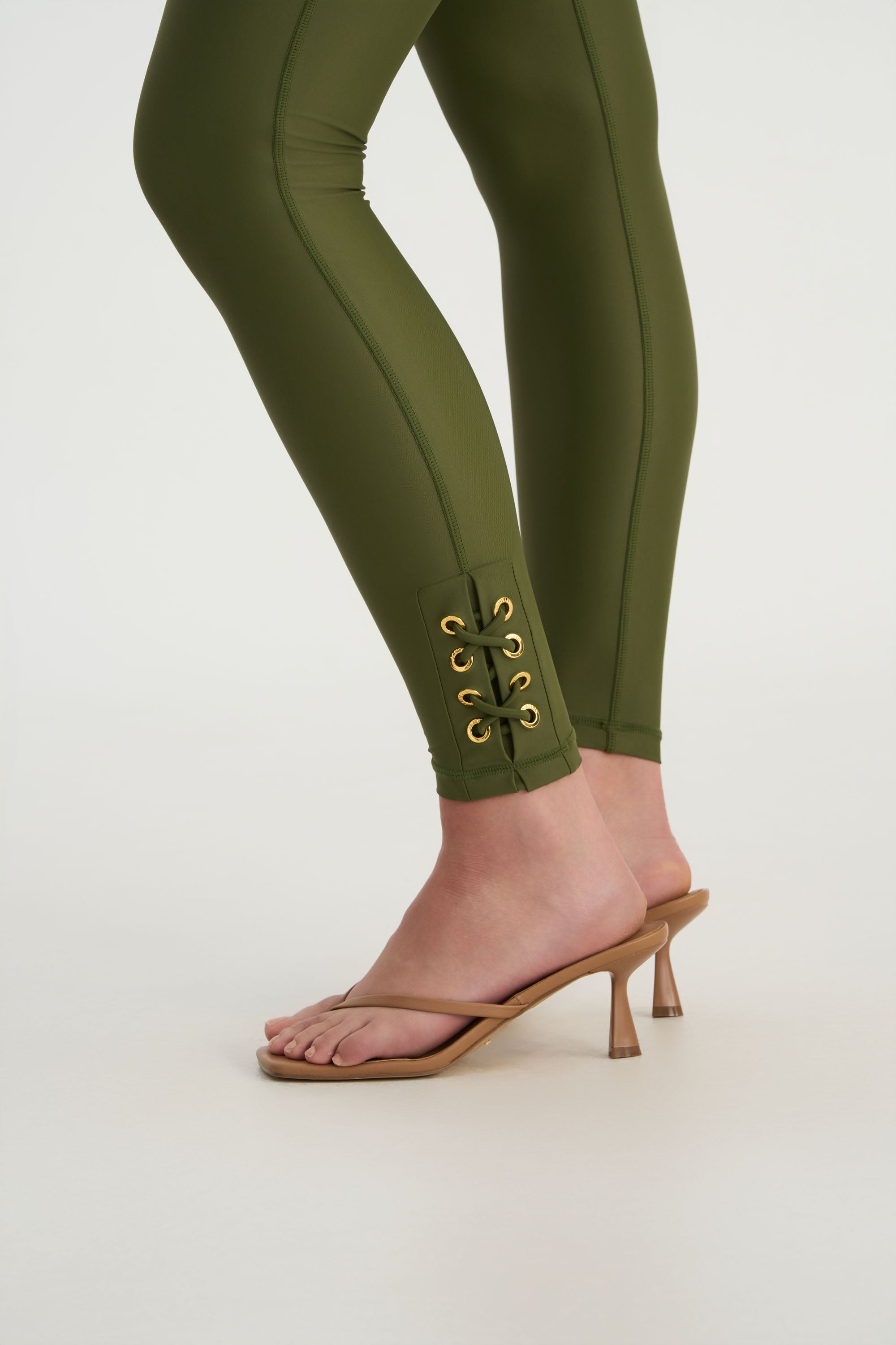 Hand-finished eyelet detailing on CEMILE black luxury swim leggings background